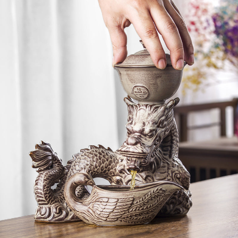 Automatic tea set brewing tea with rotating base and dragon design in use